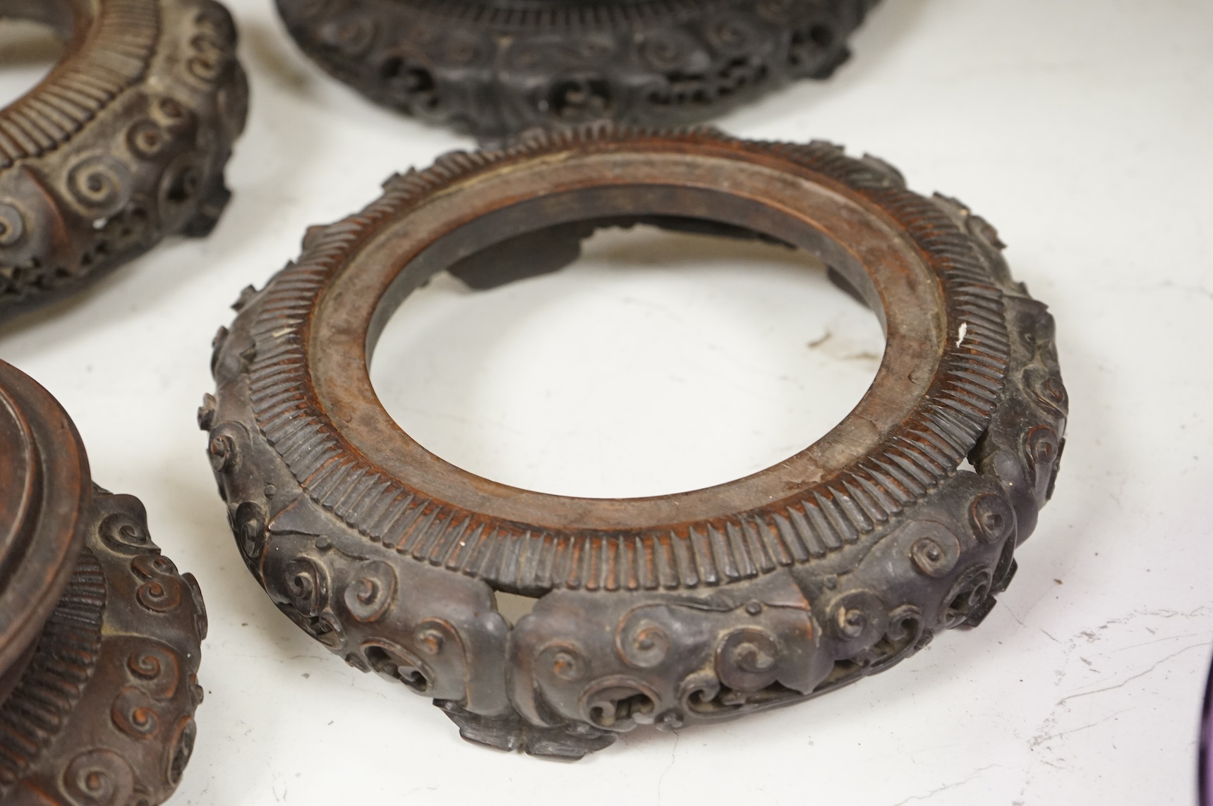 A collection of five Chinese and Japanese carved hardwood stands, late 19th/early 20th century, largest 25cm in diameter